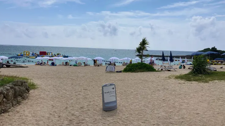 残波ビーチでアクティビティを楽しむ家族やグループ。透明な海と広い砂浜でにぎわう様子。