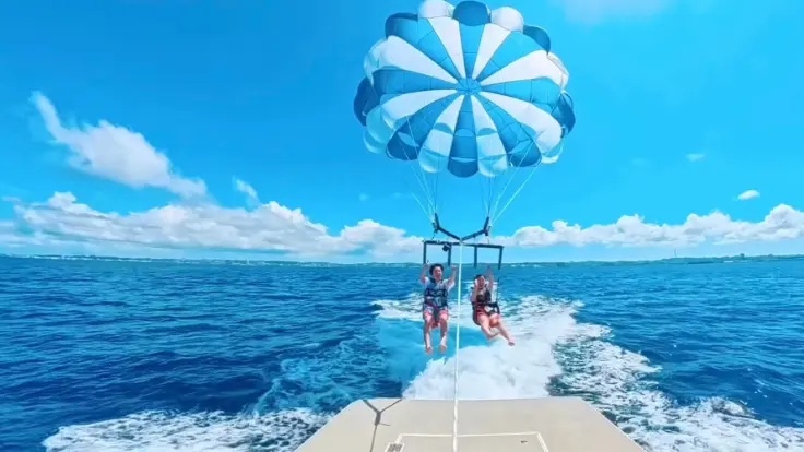 パラセーリングで飛ぶ直前の瞬間。カラフルなパラセールと沖縄の青い海が一枚におさまった景色