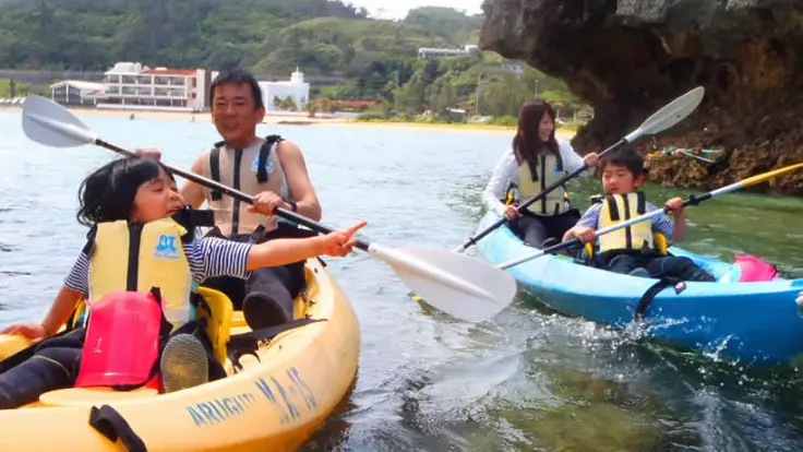 子どもと一緒にカヤックに乗って海を進んでいる様子
