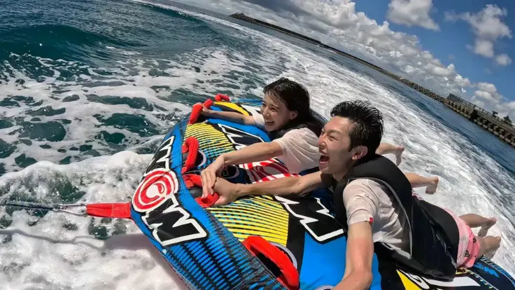 カップルがマリンアクティビティで絶叫しながら楽しんでいる様子