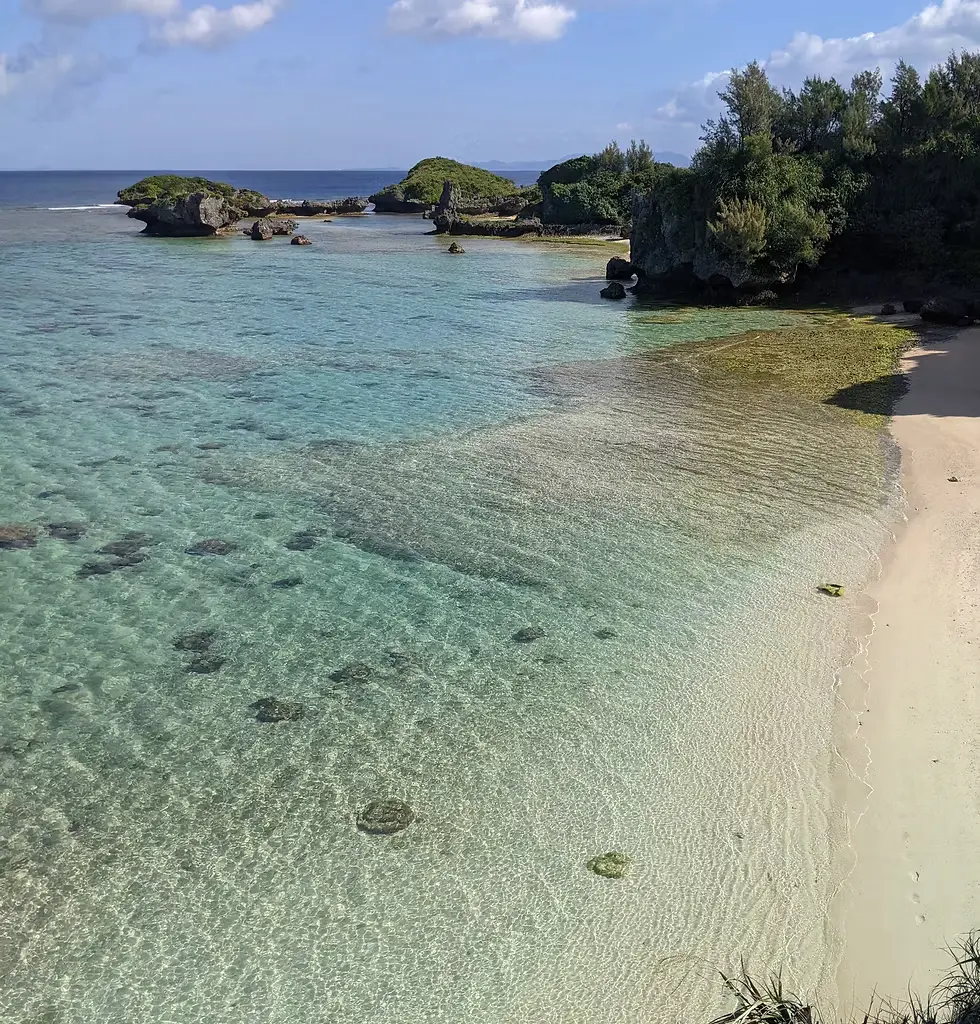 真栄田海岸のイノーに広がる干潟と珊瑚のかけらが混じった浜の風景
