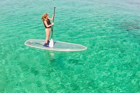 1名でも楽しめるクリアサップで女性が沖縄の海を満喫している